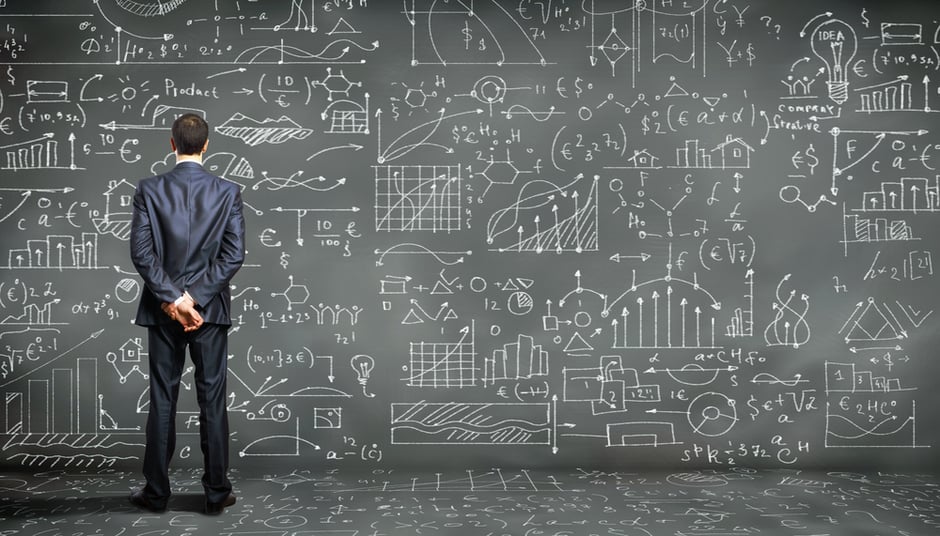 Business person standing against the blackboard with a lot of data written on it
